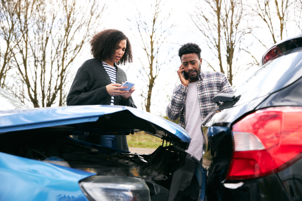 Couple exchange insurance information after a car accident