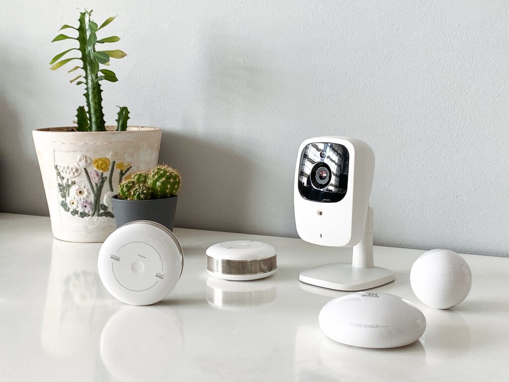 Smart home devices including a camera and water sensor on a table.