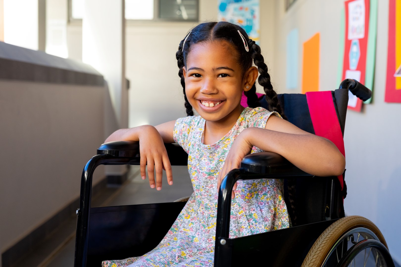 Young girl smiling while sitting in wheelchair