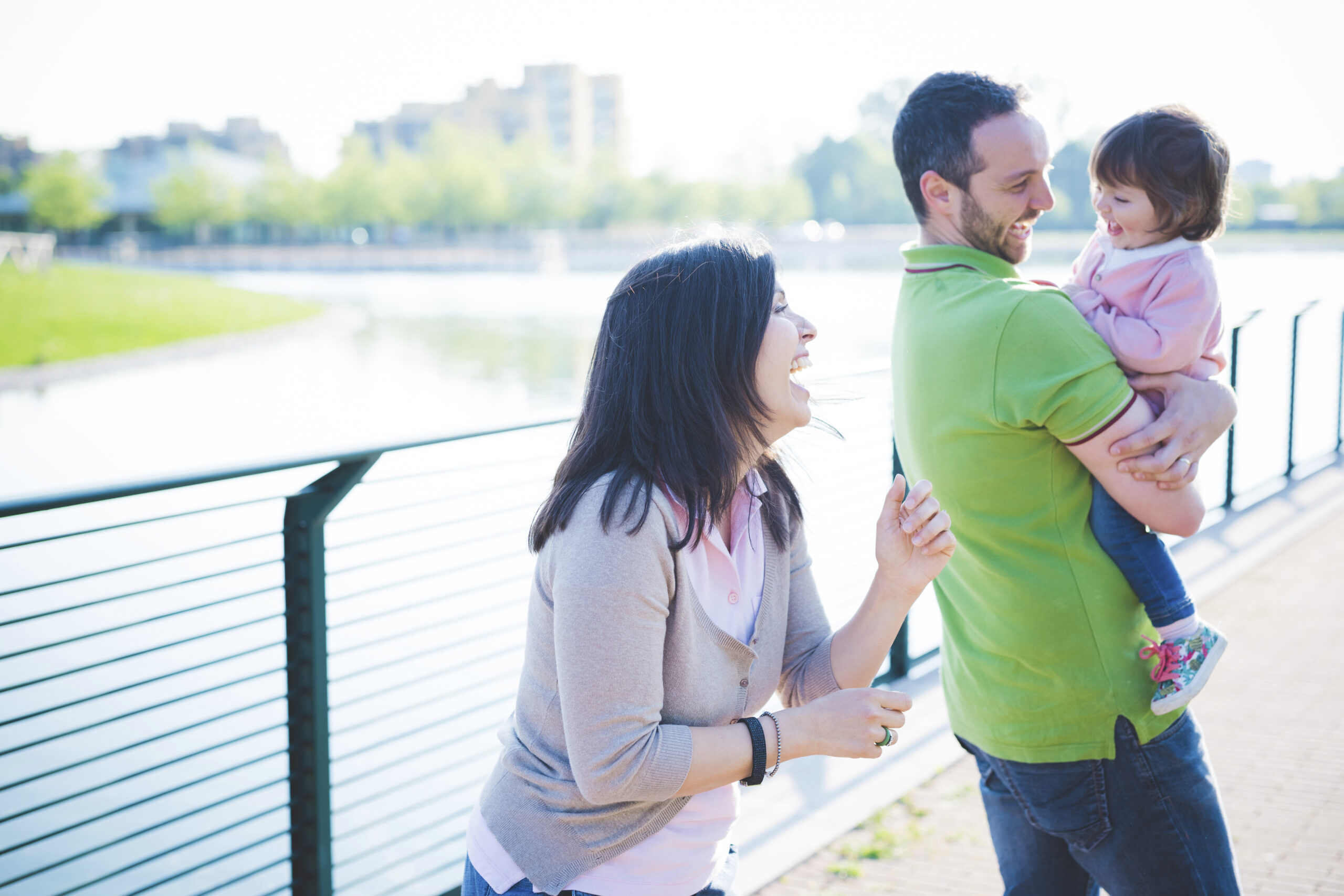 parents walking along river with toddler