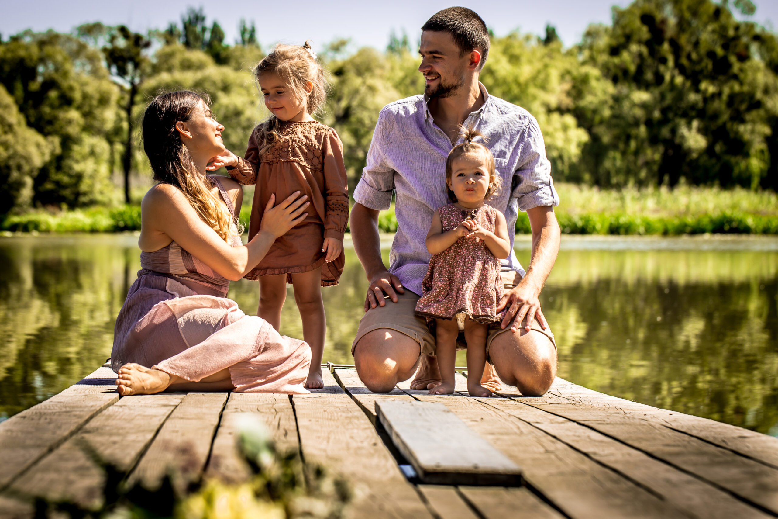 couple with two daughters on lake dock