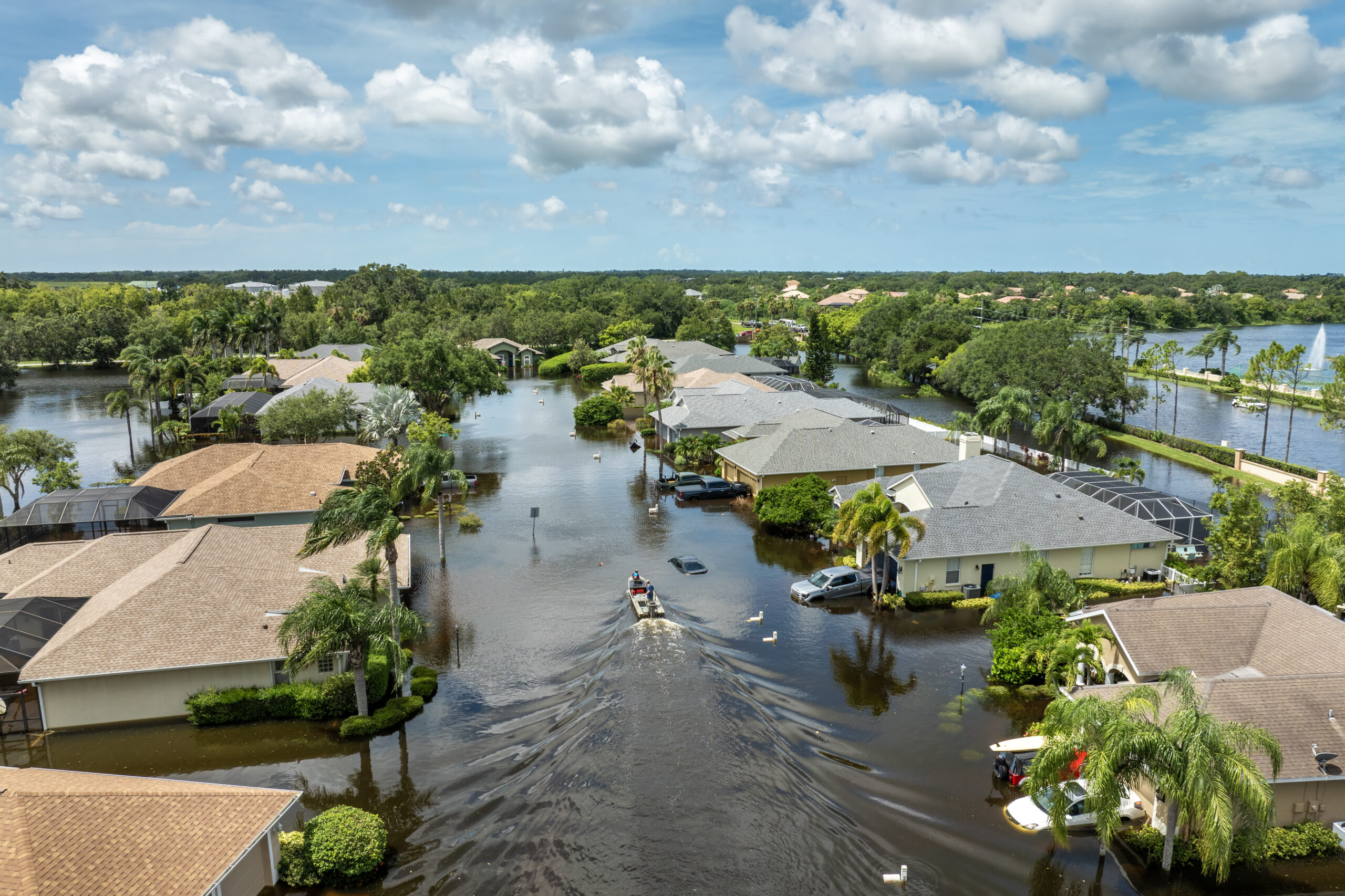 boat driving through flooded neighborhood