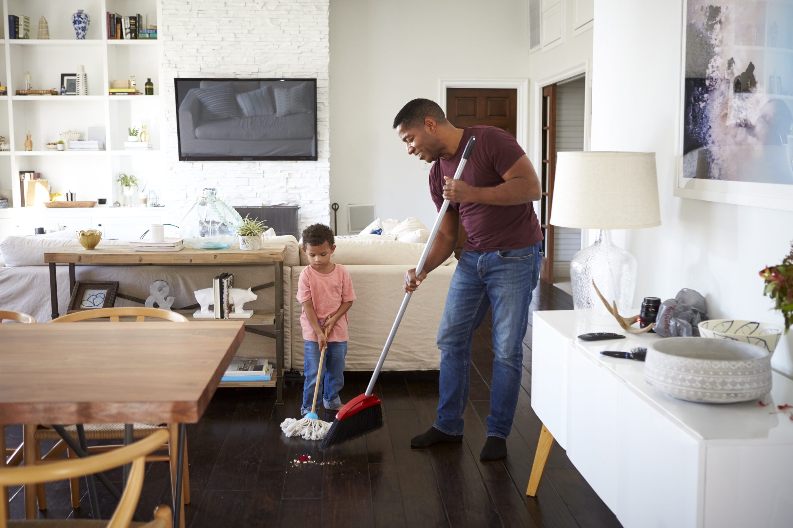 father and young son mopping the house