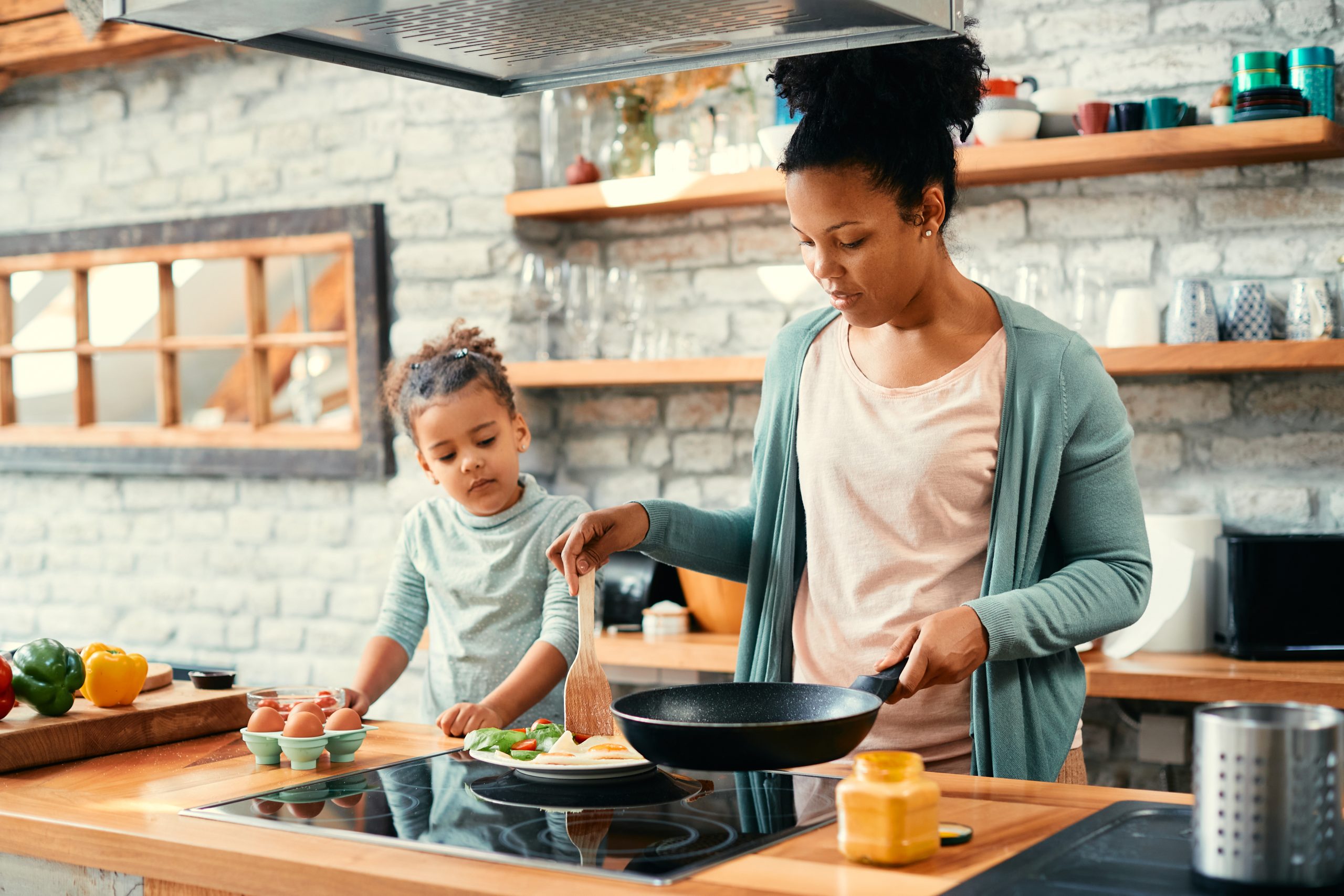 mom cooking with young daughter