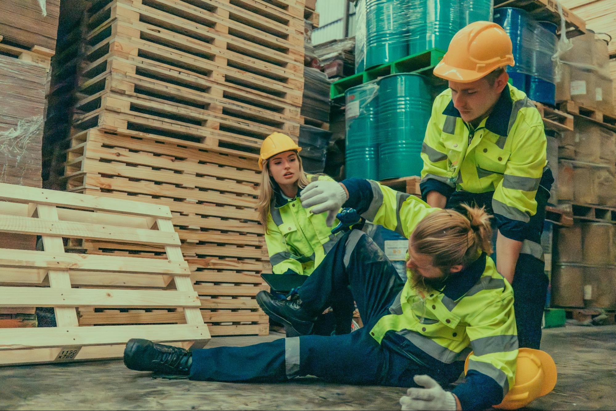 construction worker fallen on ground as coworkers help him