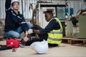 Warehouse worker sitting on floor with injured leg