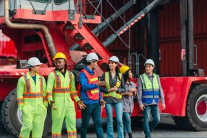 construction employees standing next to large piece of equipment
